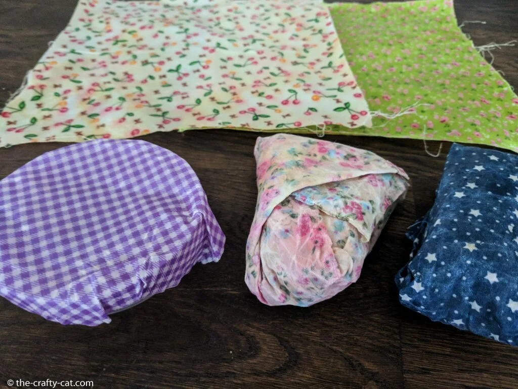 beeswax wraps on a table two flat and three wrapping something
