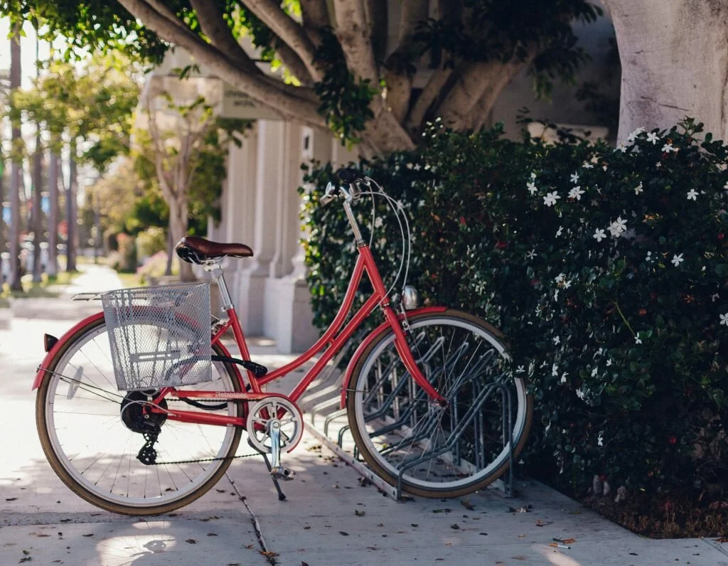 a picture of a red bicycle parked on the road